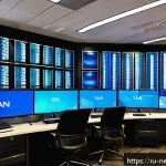 VLAN 설정 및 관리 가이드 - A detailed, modern corporate office network room featuring multiple sleek VLAN-configured network sw...